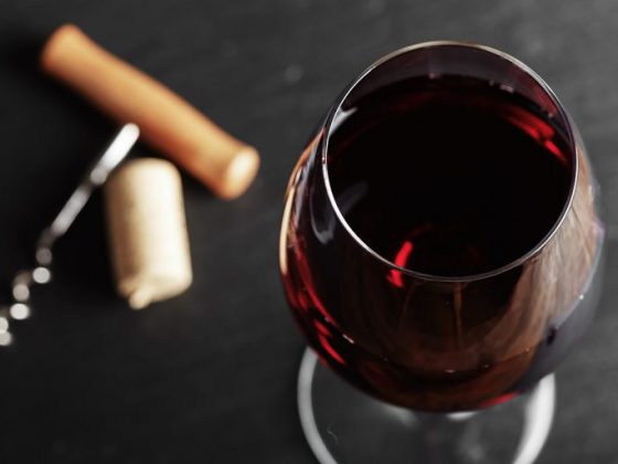 wine glass of red wine with a corkscrew.